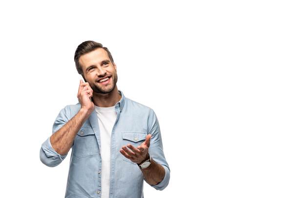 Lächelnder Mann, der auf dem Smartphone spricht und isoliert auf Weiß gestikuliert - Foto, Bild