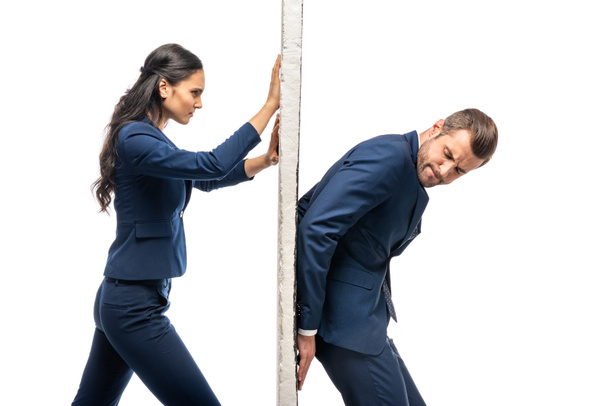 businessman and businesswoman in suits pushing wall isolated on white - 写真・画像