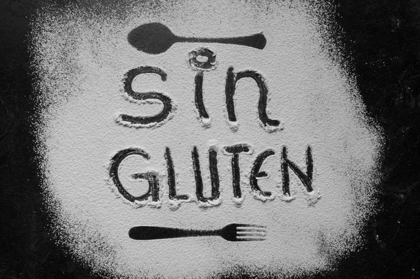 Farine sans gluten avec texte sans gluten en espagnol avec cuillère et fourchette silhouette faite avec de la farine sur fond de texture sombre
 - Photo, image