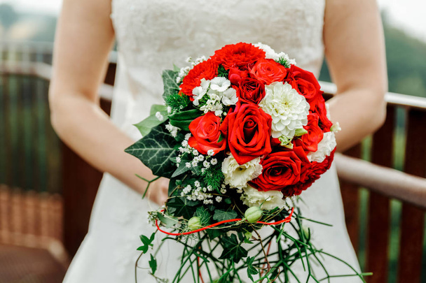 バラと緑の手渡された結婚式の花束 - 写真・画像