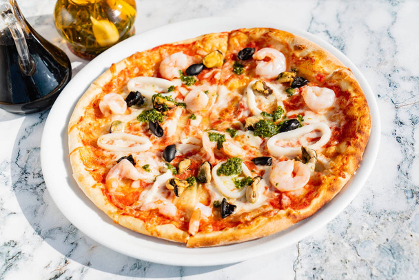 seafood pizza on the marble table, close up - Foto, Bild