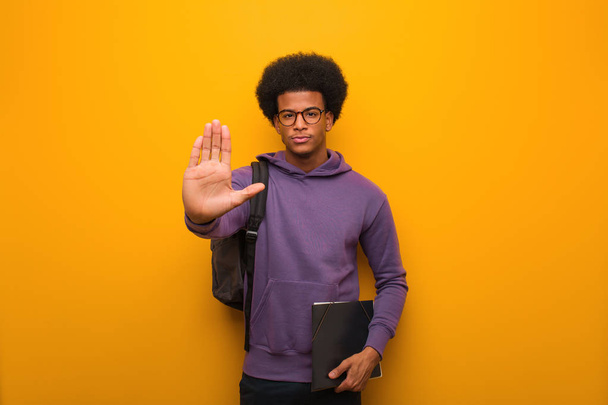 Joven afroamericano estudiante hombre poniendo la mano en frente
 - Foto, Imagen