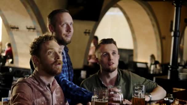 Wesoła przyjaciele picie piwa z beczki w pubie - Materiał filmowy, wideo