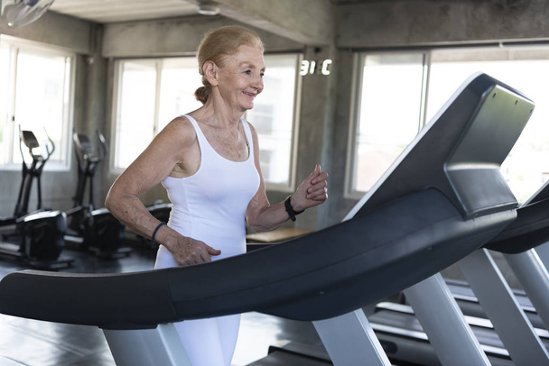 Senior women exercise jogging at gym fitness smiling and happy.  - Φωτογραφία, εικόνα