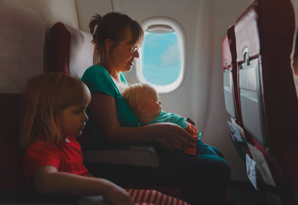 мать с двумя детьми путешествует на самолете
 - Фото, изображение
