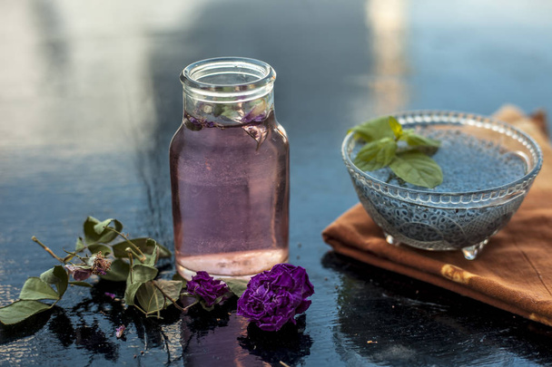 Close up of ingredients of popular Indian and Asian sherbat i.e. Gulab ka sherbat or rose milk on wooden surface which are soaked bail seeds and rose concentration or essence. - Valokuva, kuva