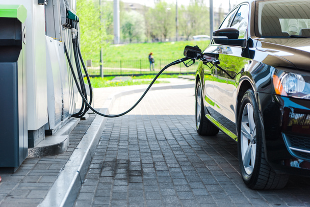reabastecimento de carro moderno preto com benzina no posto de gasolina
  - Foto, Imagem