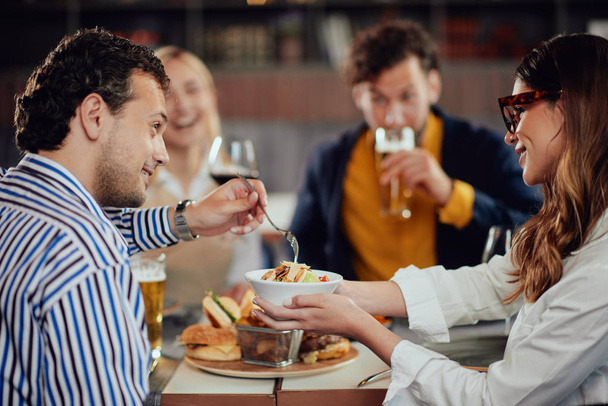 Multiethnic friends sitting at restaurant, drinking alcohol, cha - Foto, Bild