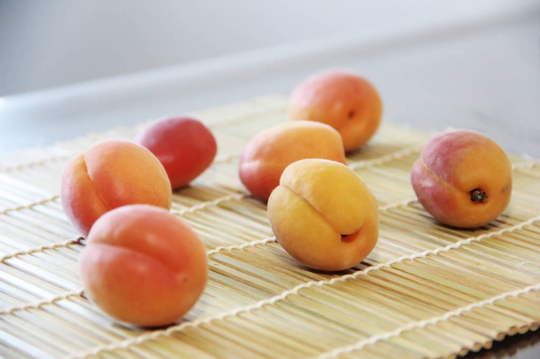 оранжевые свежие летние абрикосы на деревянном фоне ковра
 - Фото, изображение
