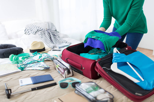 woman packing travel bag at home or hotel room - Fotó, kép