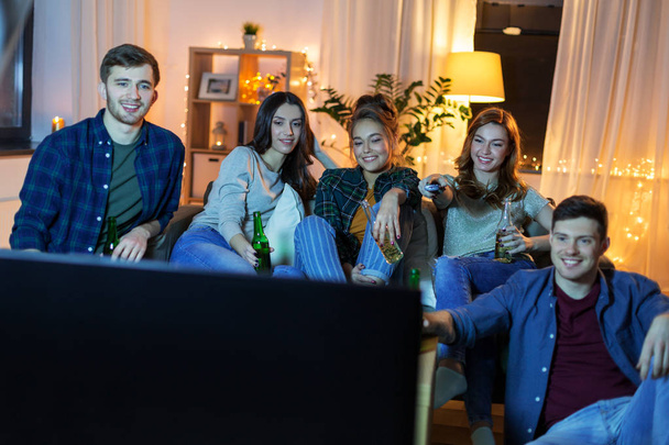 happy friends with drinks watching tv at home - Valokuva, kuva