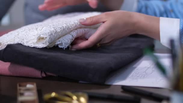 Mãos femininas escolhendo tecidos na oficina de costura
 - Filmagem, Vídeo