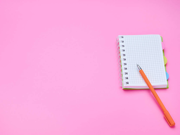 top view of the table of a teenage child, composition of a pencil notebook on a pink background - Foto, immagini