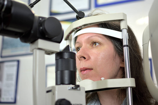 bastante joven mujer sometida a una inspección del fondo ocular con oftalmólogo, baja profundidad de campo
 - Foto, imagen