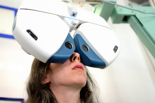 giovane bella donna sottoposto a procedura di montaggio lente con attrezzature oftalmologiche automatizzate, bassa profondità di campo
 - Foto, immagini
