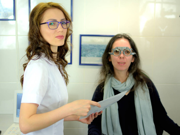 jeune jolie femme a subi une procédure d'ajustement de lentille dans un style vintage test de lentille cadre correspondant avec ophtalmologiste optométriste opticien, faible profondeur de champ
 - Photo, image