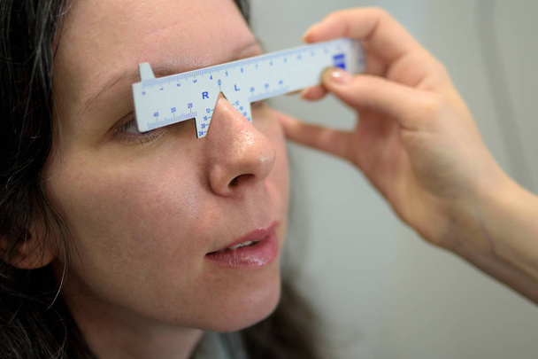 Augenarzt Augenoptiker Augenmaß für eine hübsche junge Patientin, geringe Schärfentiefe - Foto, Bild