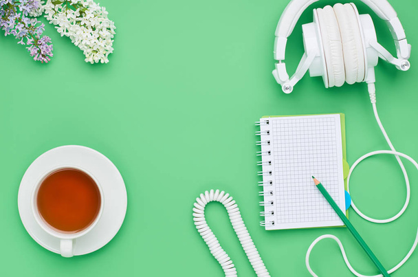top view of the table of a teenage child, composition headphones notebook pencil flower drink Lollipop on light green background - Фото, зображення