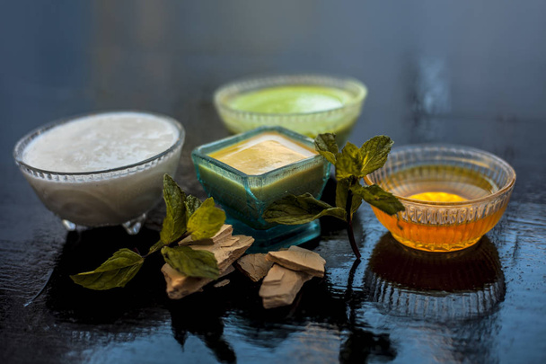 Best face pack or ubtan to remove excess oil from skin on wooden surface consisting of mentha leaves or mint leaves along with fuller's earth or bleaching clay and curd with honey. - Valokuva, kuva