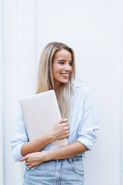Beautiful smiling girl holding laptop computer - Foto, Imagem