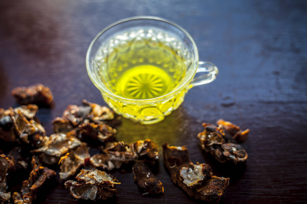 Raw organic garmalo or amaltas or golden shower tree with its extracted herbal and beneficial tea in a transparent glass cup taken with some added sugar.For the remedy of constipation. - Photo, Image