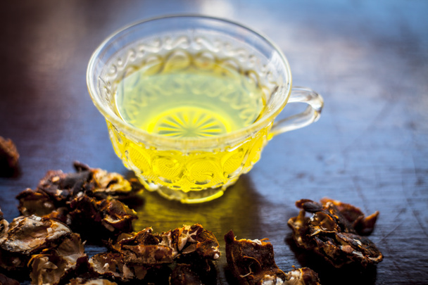 Garmalo orgânico cru ou amaltas ou árvore de banho dourada com seu chá herbal e benéfico extraído em uma xícara de vidro transparente tomada com um pouco de açúcar adicionado.Para o remédio de constipação
. - Foto, Imagem