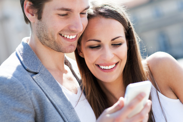 uśmiechający się para z telefonu komórkowego - Zdjęcie, obraz