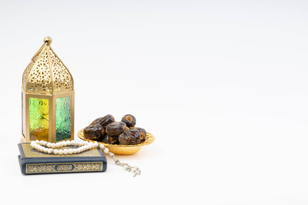 Lanterna, Datas, Alcorão e Rosário sobre fundo branco com foco seletivo e fragmento de colheita. Ramadã, Religião e Copiar conceito de espaço
 - Foto, Imagem