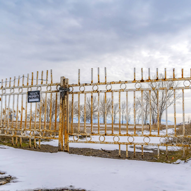 Piazza Proprietà privata con un cartello No Trespassing sul cancello arrugginito visto in inverno
 - Foto, immagini