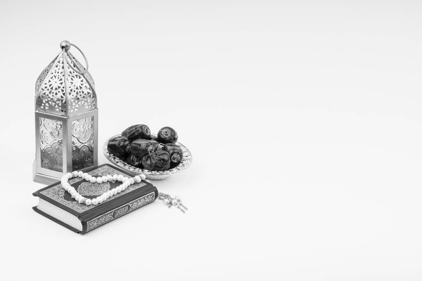 Lanterne, Dates, Coran et Rosaire sur fond blanc avec foyer sélectif et fragment de culture. Ramadan, concept d'espace de religion et de copie. Concept noir et blanc
 - Photo, image