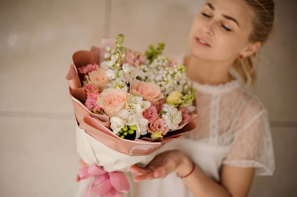 Cute girl in white blouse holding bouquet - Foto, afbeelding