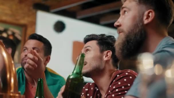 Τρεις άνδρες βλέποντας παιχνίδι ποδοσφαίρου στην παμπ  - Πλάνα, βίντεο