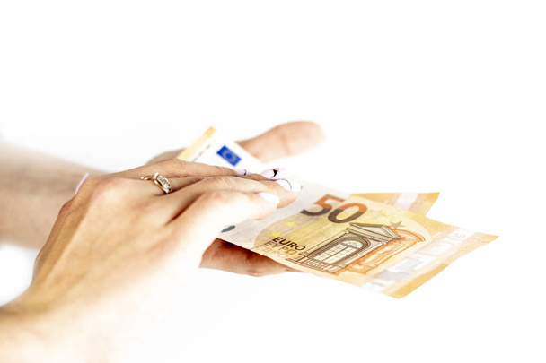 Plan recadré d'une femme méconnaissable tenant un billet en euros sur un fond blanc isolé
 - Photo, image