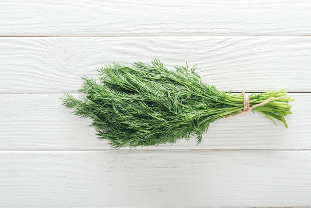 top view of fresh green dill on white wooden table - Fotoğraf, Görsel