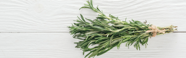 top view of fresh green rosemary on white wooden table, panoramic shot - Fotó, kép