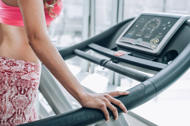 Attractive muscular smiling fitness woman running on treadmill i - Photo, Image