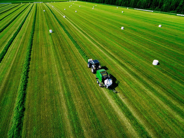 Вид с воздуха на зеленое поле для косьбы тракторов в Финляндии
. - Фото, изображение