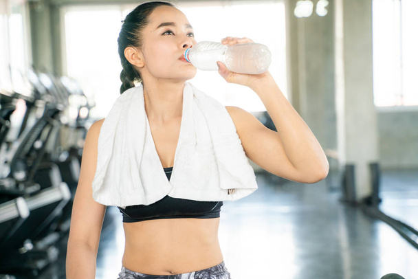 Sporty asian women drinking water in bottle - Foto, immagini