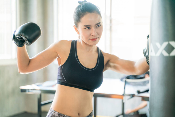 パンチバッグでボクシングトレーニングをしているアジアの若い女性 - 写真・画像
