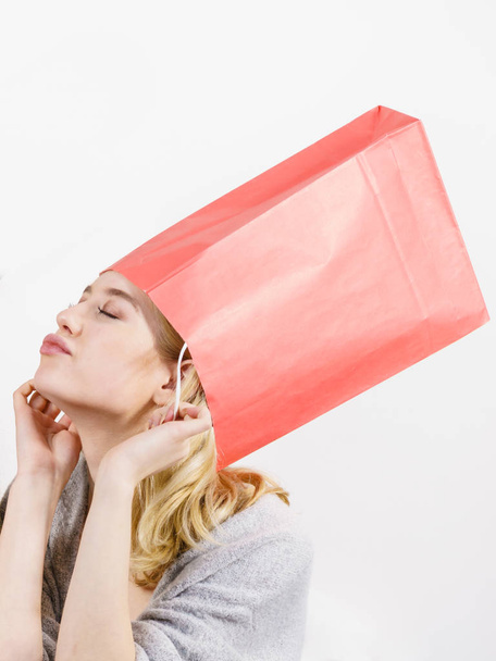 Woman wearing shopping bags on head - Foto, imagen