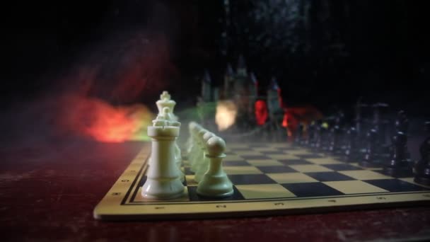 Šachy desková hra koncept podnikatelských nápadů a precizní strategie a soutěž myšlenek. Šachové figury na tmavém pozadí se kouře a mlhy. - Záběry, video