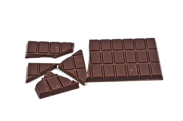 Broken dark chocolate bar isolated on white. - Photo, Image