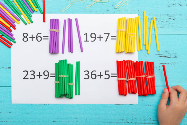 gyerek csinálás összeadás egyenleteket használ számolás rúd - Fotó, kép