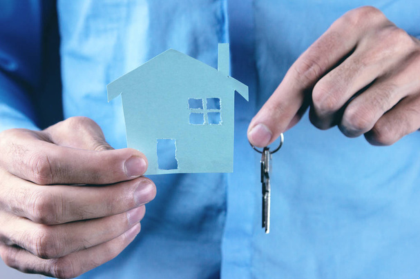 Agente imobiliário com modelo de casa e chaves
 - Foto, Imagem
