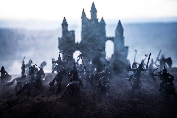 Μεσαιωνική σκηνή μάχης με ιππικό και πεζικό. Σιλουέτες προσωπικοτήτων ως ξεχωριστά αντικείμενα, πάλη μεταξύ των πολεμιστών στο ηλιοβασίλεμα φόντο ομίχλη. - Φωτογραφία, εικόνα
