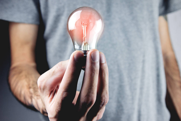 Businessman holding light bulb. Concept of new idea - Фото, изображение