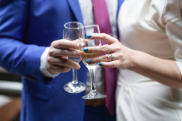 Schnappschuss eines Mannes und einer Frau, die Champagnerflöten in der Hand halten und anstoßen, Konzept der Paarfeier, eines Hochzeitstoastes, einer Nacht mit Freunden oder Kollegen oder gesellschaftlicher Akzeptanz gelegentlichen Trinkens - Foto, Bild