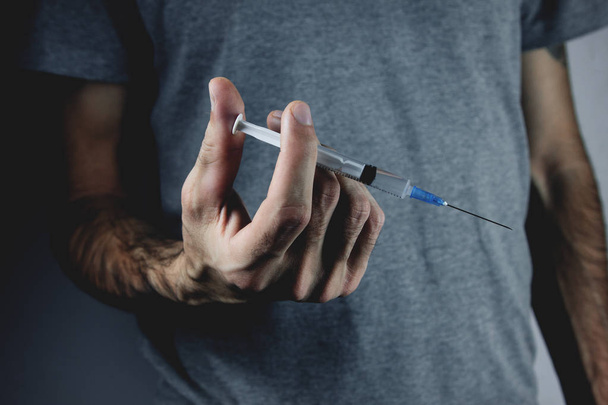 drug addict holding a syringe - Фото, изображение