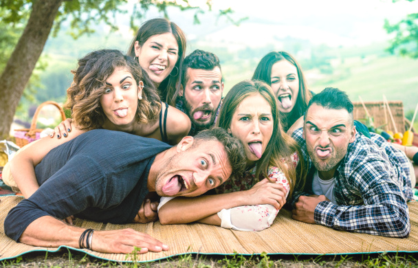 Millenial friends machen Selfie mit lustigen Gesichtern beim Picknick-Grillen - Happy Youth Friendship Konzept mit Millennial young people having fun together with Zunge raus - leuchtend grüner Azurfilter - Foto, Bild