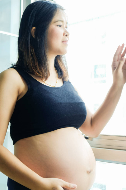 Jovens mulheres grávidas bonitas em pé no quarto acolhedor
 - Foto, Imagem